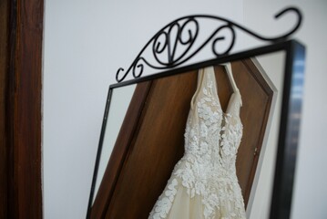 Reflection of an elegant wedding dress with lace details in a vintage mirror