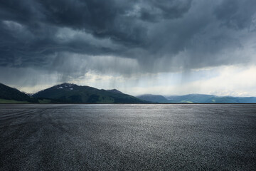 Asphalt road square and mountain with black rain clouds natural landscape before the rainstorm