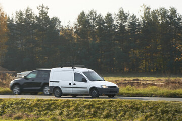 White van speeds along a scenic country road