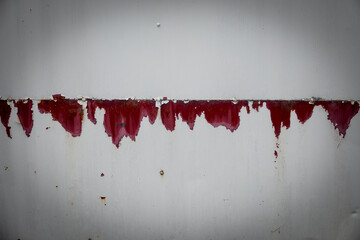 A wall with red paint dripping down 
