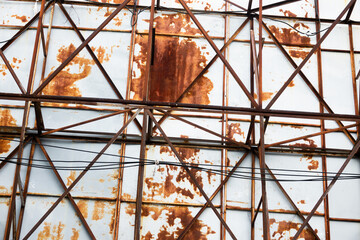 A rusted metal structure with wires running through it