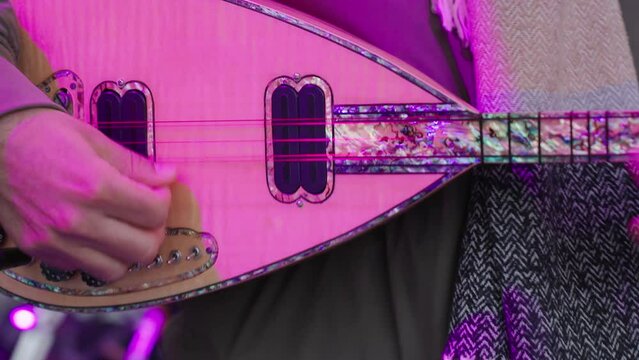 detail of saz playing in the orchestra, traditional Turkish musical instrument, Baglama