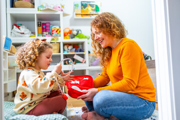 Girl playing nurses with aid kit toy with her mother