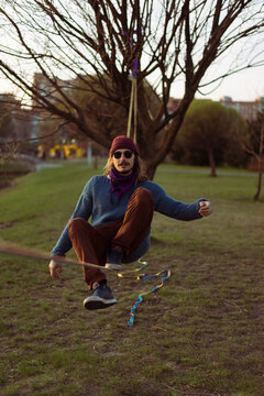 Young man sitting on a slackline.