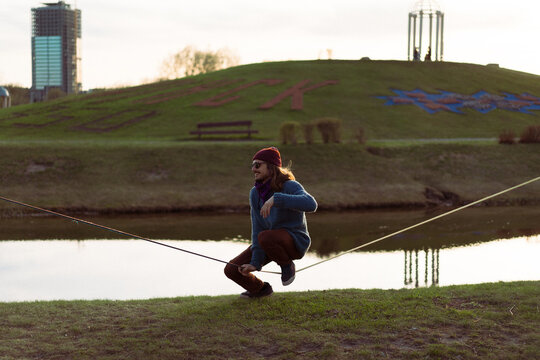 Young man sitting on a slackline.