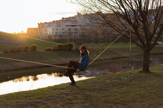 Young man sitting on a slackline.