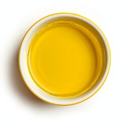 Top view of yellow liquid in a petri dish or glass with bubbles on a white background.