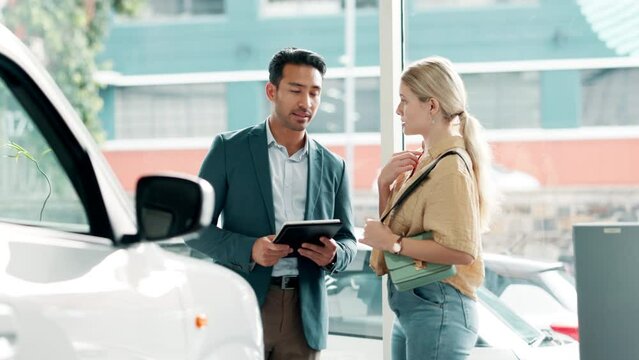 Woman, man and tablet in car dealership for advice, negotiation or consulting in vehicle finance. Discussion, salesman and customer shopping in transport showroom with digital app for auto insurance