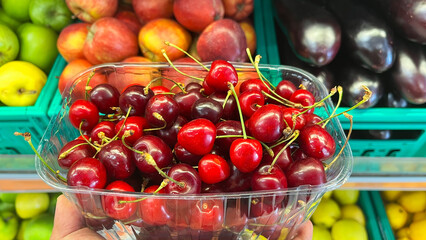 Fresh red cherry in the plastic box ready for sell in the fruit market.