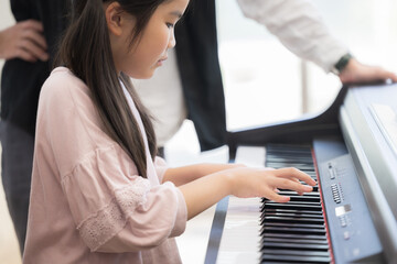 ピアノを弾く子供の横顔と手元のクローズアップ
