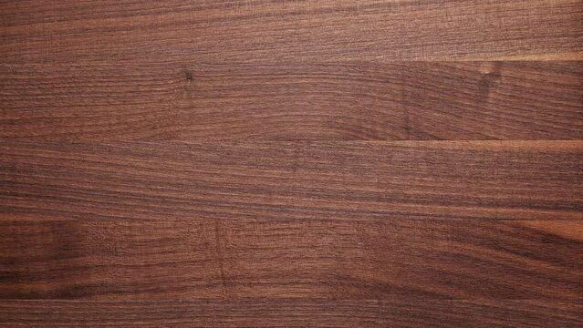 Dark walnut wood desktop background. Dark walnut wood texture background. Desktop background moving up and down. Empty desktop.