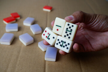 man's hand holding many dominoes