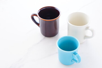 コーヒーを飲むために、お気に入りのおしゃれな3つのマグカップから、今日のひとつを選ぶ
