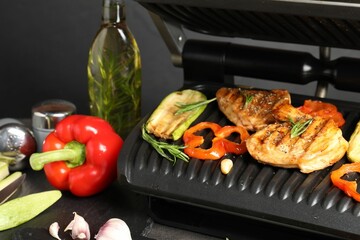 Electric grill with different products on grey table