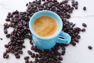 エスプレッソに牛乳をたっぷり入れたコーヒー、カフェ・ラッテと、深煎りしたコーヒー豆
