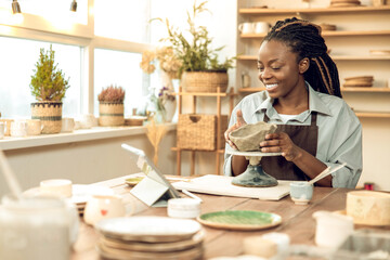 Dark-skinned beautiful sculptor conducting online class on ceramics