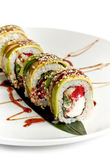 Green dragon sushi roll with eel and avocado on a white plate