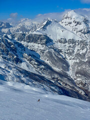 Majestic snowy mountain scenic with a snowboarder riding fresh powder snow