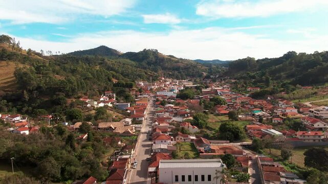 Delfim moreira, minas gerais, brazil, showing the scenic town surrounded by lush hills, aerial view.