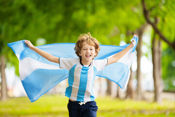 Child running with Argentina flag. Argentinian fan