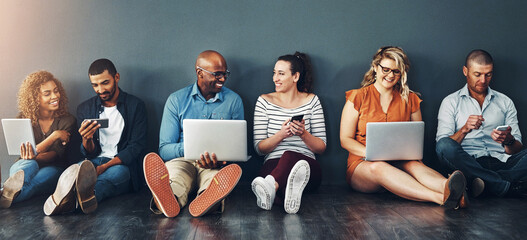 Technology, people and collaboration sitting on floor for teamwork, communication and diversity in office. Group, men and woman online for social media post, internet browsing or company research