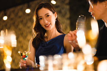 バーでお酒を飲む若い男女