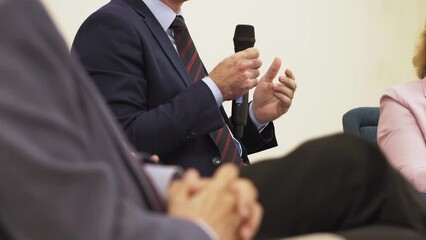 Businessman speaks at conference hall. Man holds a microphone and speaks at a business forum