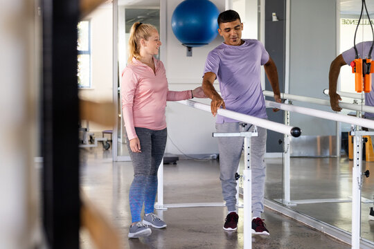 Biracial man and female physical therapist engaging in rehabilitation exercises