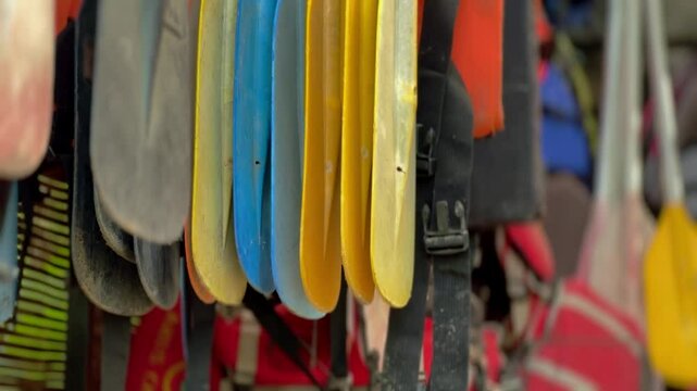 Plastic boat paddles hanging in storage room, close up view