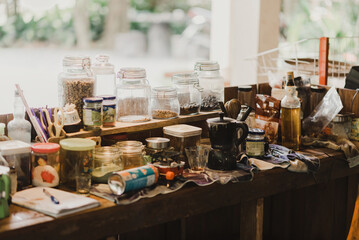 A cluttered rustic kitchen workspace with jars, spices, utensils, and bottles. Perfect for cozy, homey, and earthy-themed designs or DIY cooking and crafting events.