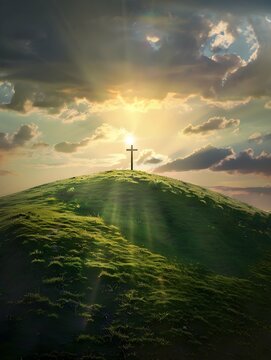 Cristian cross on top of a green hill at sunset