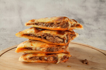 Stuffed chicken breaded naan flatbread cut in triangle pieces.