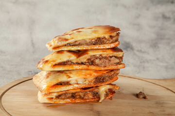 Stuffed chicken breaded naan flatbread cut in triangle pieces.