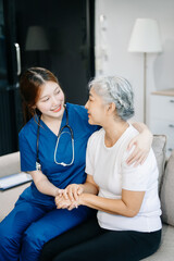Obraz premium Asian caregiver doctor examine older patient woman therapist nurse at nursing home taking care of senior elderly woman sit on sofa.Medical service concept.
