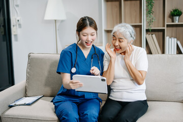 Asian caregiver doctor examine older patient woman therapist nurse at nursing home taking care of...