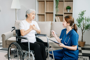 Asian caregiver doctor examine older patient use blood pressure gauge. woman therapist nurse at nursing home taking care of senior elderly woman sit on sofa