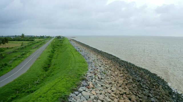 Aerial: Sea dyke view along the road, fast flyover, North Atlantic Ocean and Nickerie Suriname