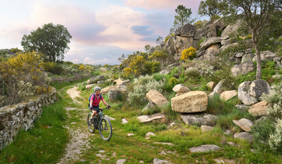 Fototapeta premium active senior woman cycling with her electric mountain bike in the rough landscape of National Parc Serra de São Mamede near Marvao in central Portugal, Europe 