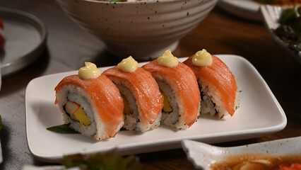California sushi rolls with salmon on wooden table. Traditional Japanese cuisine concept
