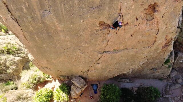 Man rock climbing aerial view of sportsman rapelling mountain in La Panocha, el Valle Murcia, Spain woman rapel down a mountain climbing a big rock