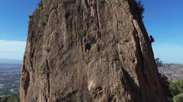 Man rock climbing aerial view of sportsman rapelling mountain in La Panocha, el Valle Murcia, Spain woman rapel down a mountain climbing a big rock