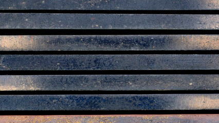 The image is a close up of a black and white striped surface. The stripes are of varying widths and are arranged in a pattern. The surface appears to be made of concrete or some other type of material