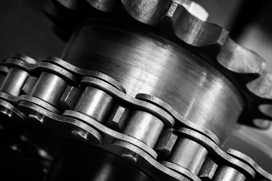 Gear chain drive shaft in conveyor belt is on production line. Timing chain of car, tensioners in engine. Industrial roller chain, technology. Team work, business industrial concept