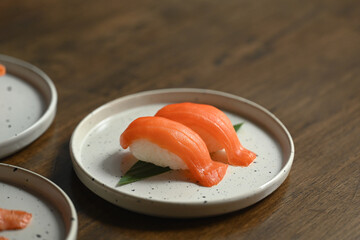 Delicious nigiri sushi with salmon on ceramic plate. Japanese food style concept