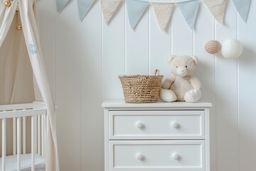 Stylish white baby room interior with wood chest of drawers and cute flags. Baby clothes, teddy bear toys on a eco shelf in children's room. Baby's stuff, trendy chest near beige wall. Space for text.