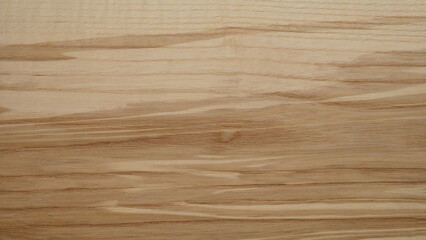 Naklejka premium A wooden surface with a grainy texture background. The wood appears to be aged and has a natural, rustic feel to it. The grain of the wood is visible in the image