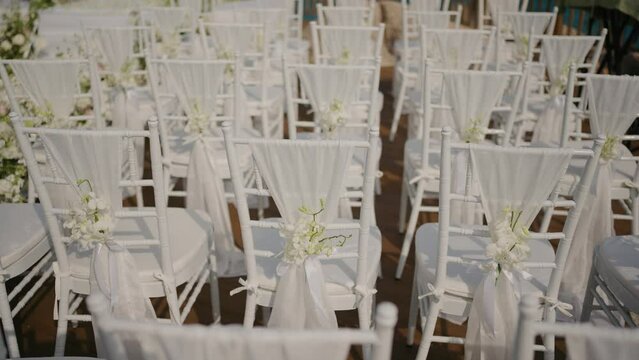 Wedding decoration chairs  White plastic Chiavari chairs in rows. Outdoor wedding ceremony, event, seminar or party with no people.