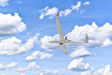 Single-engine ultralight aircraft plane flying in the blue sky with white clouds