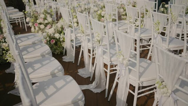 Wedding decoration chairs  White plastic Chiavari chairs in rows. Outdoor wedding ceremony, event, seminar or party with no people.