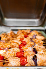 Marinated chicken and vegetables on skewers being grilled, perfect for culinary and food-related themes.